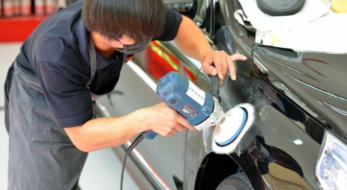 man buffing the side of a car